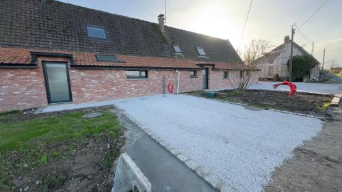 a brick house with a driveway in front of it at La ferme Le Clos de la Becque in Muncq-Nieurlet