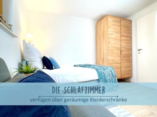 a bedroom with a bed and a wooden cabinet at Höfthus 9 Holla die Boddenfee Meerblick Terrasse mit Hund die Natur genießen in Alt Reddevitz
