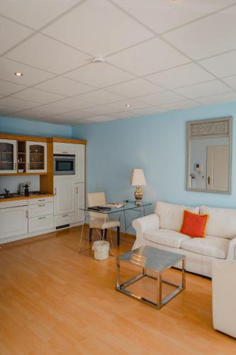 a living room with a white couch and a table at Hotel Stadtresidenz in Hildesheim