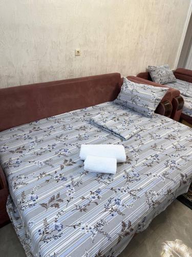 a bed with a blue and white blanket on it at Nugzar House Chakvi - 2 Bedrooms in Chakvi
