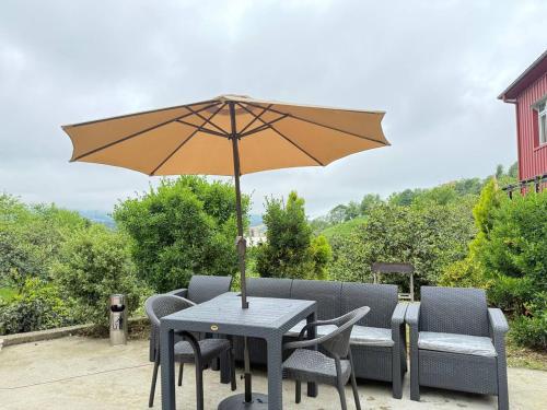 a table and chairs with an umbrella on a patio at Nugzar House Chakvi - 2 Bedrooms in Chakvi