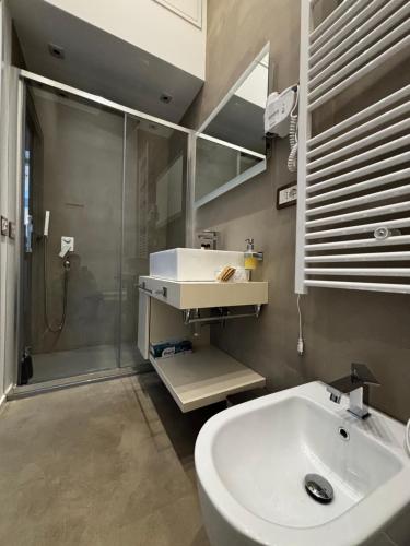 Un baño con lavabo blanco y ducha. en Suite and loft, en Sabaudia