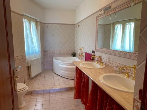 a bathroom with two sinks and a tub and a toilet at VILLA DAL PESCATORE Apartment - Elegant Retreat between Anzio & Nettuno with Garden and refined Patio - Train Station 500mt in Nettuno