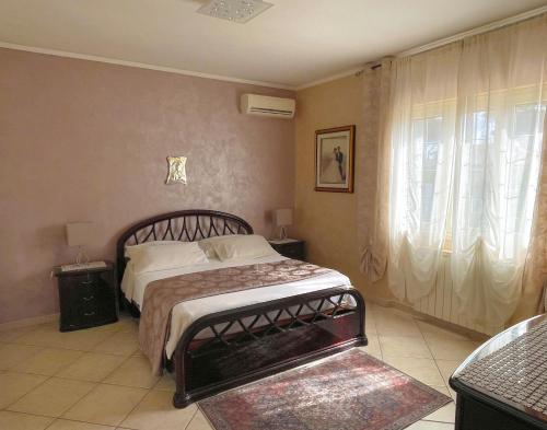 a bedroom with a bed and a large window at VILLA DAL PESCATORE Apartment - Elegant Retreat between Anzio & Nettuno with Garden and refined Patio - Train Station 500mt in Nettuno