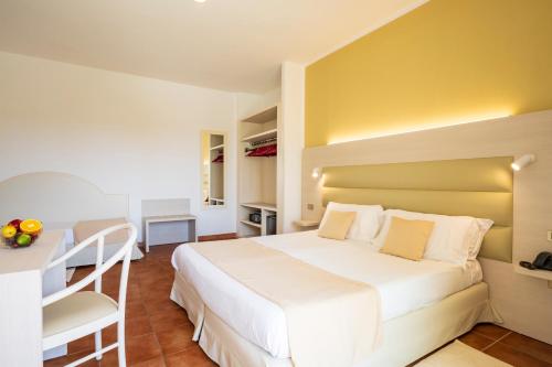 a bedroom with a large white bed and a desk at Hotel Florida in Alghero