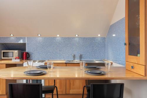 a kitchen with a table with plates and glasses at Newton House - Free Parking in Whitby
