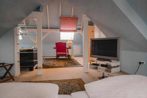 a living room with a bed and a tv in a room at Hotel Stadtresidenz in Hildesheim