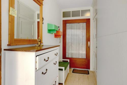 eine Küche mit weißen Schränken und einer roten Tür in der Unterkunft Ferienwohnung Kleeblatt in Markelfingen