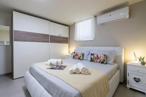 a bedroom with a bed with towels on it at Rosa dei Venti 2 in Alghero