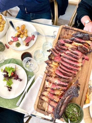 a table with a tray of meat and plates of food at Les Hayes en Sologne in Fontaines-en-Sologne