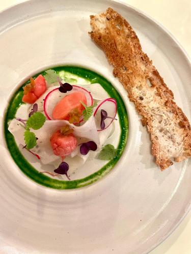a white plate with a salad and a slice of bread at Les Hayes en Sologne in Fontaines-en-Sologne