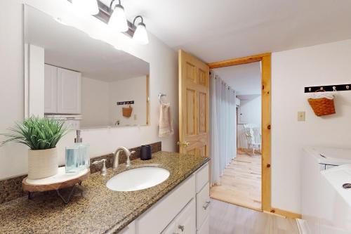 a bathroom with a sink and a mirror at Maine Lake Family Retreat in Monmouth