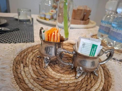 a table with two tea pots with carrots in them at Armonie di Campagna Rooms & Breakfast di Valentini Sabina in Calderara di Reno