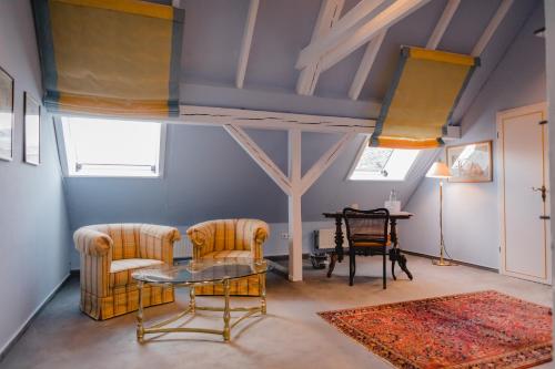 a living room with two chairs and a table at Hotel Stadtresidenz in Hildesheim