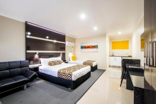 a hotel room with two beds and a couch at Abbey Motor Inn in Grafton