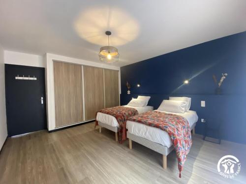 a bedroom with two beds and a blue wall at Aqui sem be in Amélie-les-Bains-Palalda