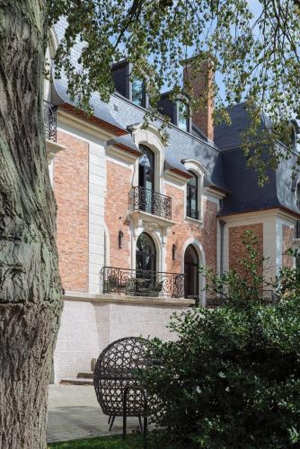 a bench sitting in front of a building at Bienheureux Hôtel & Restaurant in Wasquehal