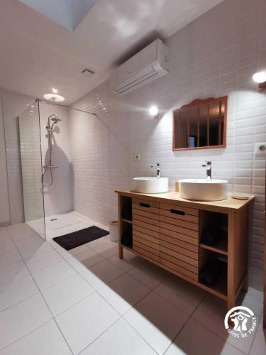 une salle de bain avec deux lavabos et une douche dans l'établissement Chez jordan, à Pomérols