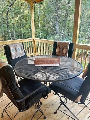 a patio table and chairs on a deck at Cozy Cabin Getaway! in Fancy Gap