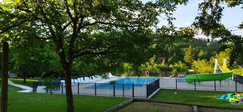 une piscine dans un parc avec un arbre dans l'établissement Camping le Convivial Cottage climatisé 6-8 personnes, à Saint-Martial-de-Nabirat