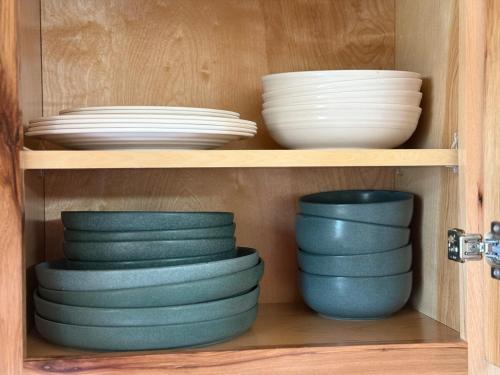 a shelf with plates and bowls in a cabinet at Cozy Cabin Getaway! in Fancy Gap