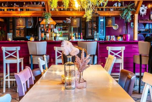 Una mesa en un restaurante con paredes moradas y una barra. en Lila aan zee - Recreatiepark de Watersnip, en Petten