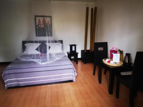 una camera da letto con un letto grande e un tavolo di La Pernela Resort a Dauis