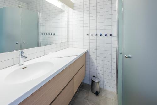 Baño blanco con lavabo y espejo en Ekerum Resort Öland, en Rälla