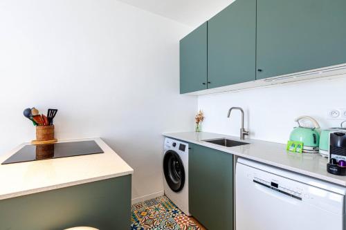 une cuisine avec un évier et une machine à laver dans l'établissement GuestReady - Chic Parisian nest near the Metro, à Paris