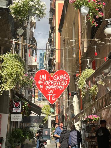 a street with a heart sign hanging from buildings at Casetta Piazza Plebiscito in Naples