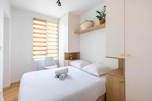 - une chambre dotée d'un lit blanc avec un jouet dans l'établissement GuestReady - Chic Parisian nest near the Metro, à Paris