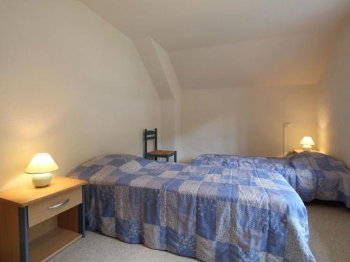 una camera con un letto e un tavolo e due lampade di Gîte pittoresque en bord de rivière avec jardin clos, proche sports et sites touristiques - FR-1-582-176 ad Alleyras