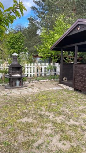 a grill in a yard next to a fence at KURNIK - Domek pod lasem in Sztabin
