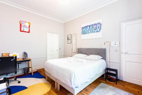 une chambre avec un lit blanc et une télévision dans l'établissement GuestReady - Refined Stay near the Eiffel Tower, à Paris