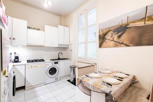 une cuisine avec une table et une machine à laver dans l'établissement GuestReady - Refined Stay near the Eiffel Tower, à Paris