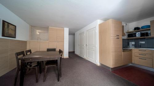 une cuisine avec une table et des chaises dans une pièce dans l'établissement C du Verdon 2503 - 2P6, à La Foux d'Allos