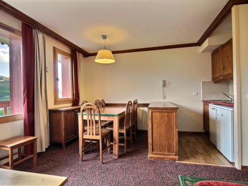 une salle à manger avec une table et des chaises et une cuisine dans l'établissement Appartement 3 pièces au pied des pistes avec balcon et vue - FR-1-455-58, à Plagne Villages