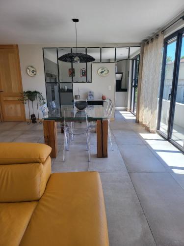 - un salon avec une table à manger et des chaises dans l'établissement Appartement standing bord Sorgue, à LʼIsle-sur-la-Sorgue