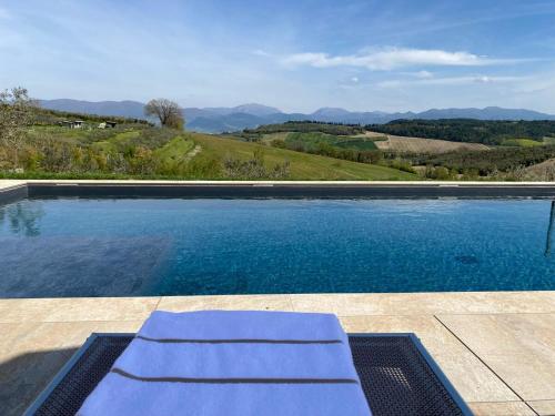 a swimming pool with a bench and mountains in the background at Casale Isidoro - Locazione Turistica 35159 in Castel Ritaldi