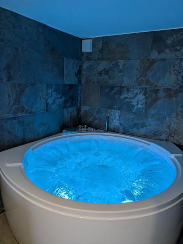 a large blue tub in a bathroom with a blue ceiling at Maison Insolite avec Spa Privatif in Monbalen