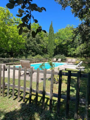 a wooden fence next to a swimming pool at Le cabanon de la bergerie in Grignan
