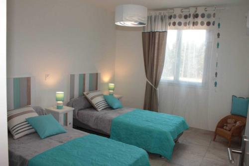 a bedroom with two beds and a window at Banyuls in Latour-Bas-Elne