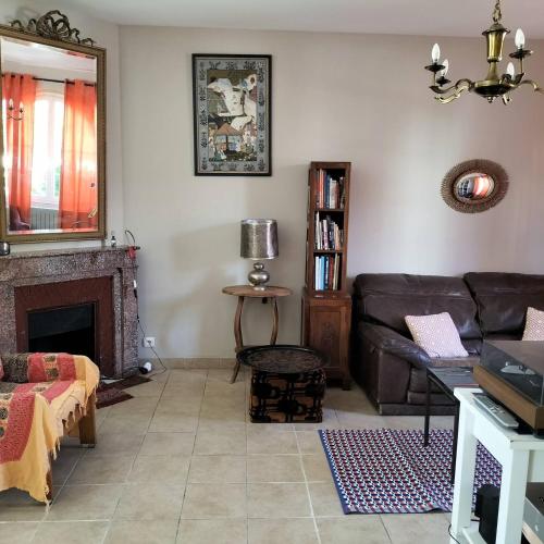 un salon avec un canapé et une cheminée dans l'établissement Maison Orphée, à La Celle-sous-Gouzon