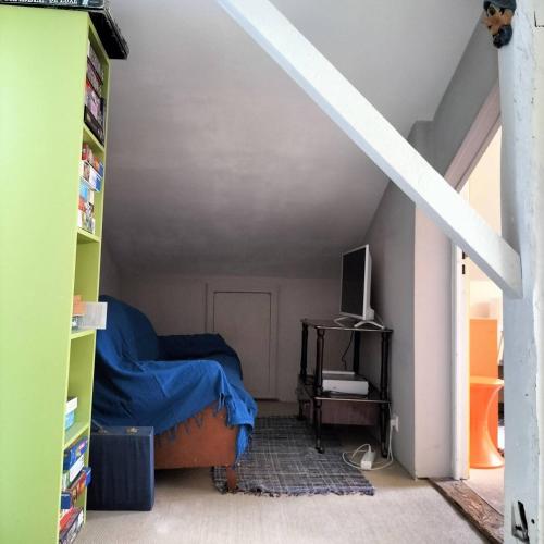 Cette chambre mansardée comprend un lit et un escalier. dans l'établissement Maison Orphée, à La Celle-sous-Gouzon