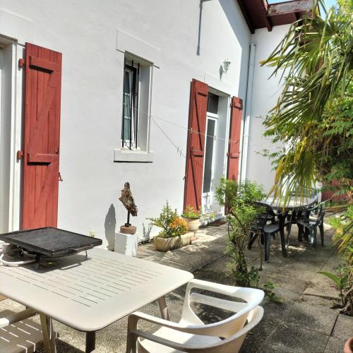 un patio avec une table et des chaises devant un bâtiment dans l'établissement Maison Orphée, à La Celle-sous-Gouzon