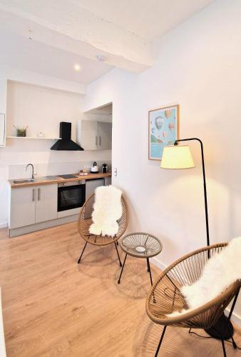 un salon avec deux chaises et une table dans l'établissement Les Bons Enfants Balnéo, à Rouen