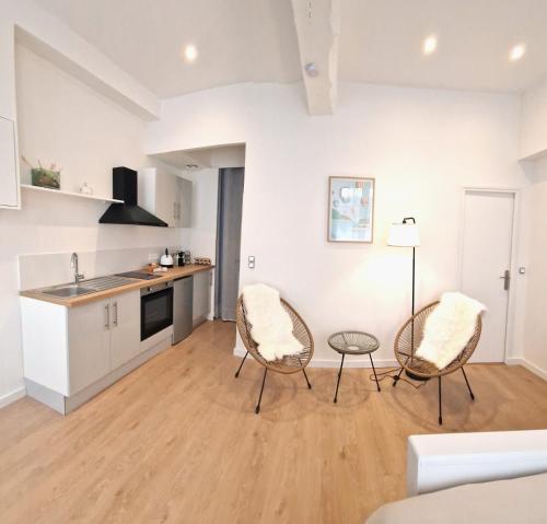 a kitchen and dining room with two chairs and a table at Les Bons Enfants Balnéo in Rouen