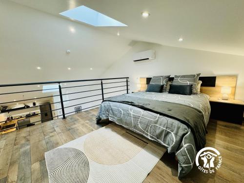 een slaapkamer met een groot bed en een dakraam bij La detente in Lézignan-Corbières