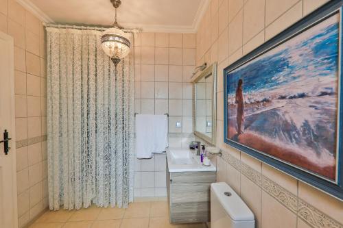 a bathroom with a sink and a painting on the wall at Villa Dolluca in Kaş