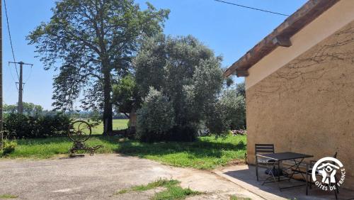 a table and a bench next to a building at Le chinchilla in Gaillac